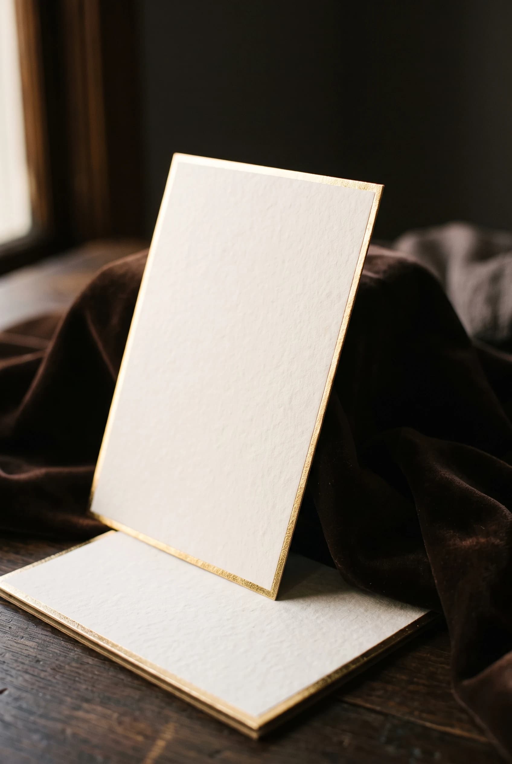 ベルベットを背にした金縁の厚紙カード